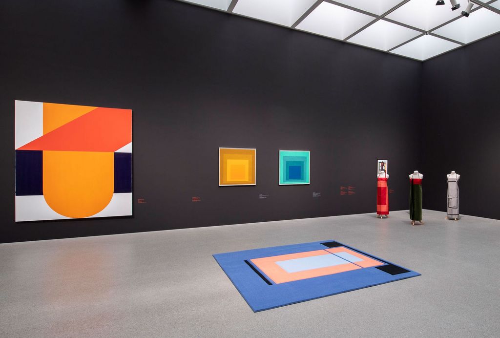 Exhibition space of the Pinakothek der Moderne with geometric-abstract paintings by Takesada Matsutani and Josef Albers, as well as textile works (carpet, clothes) by Andrea Zittel, Sammlung Goetz, Munich 
