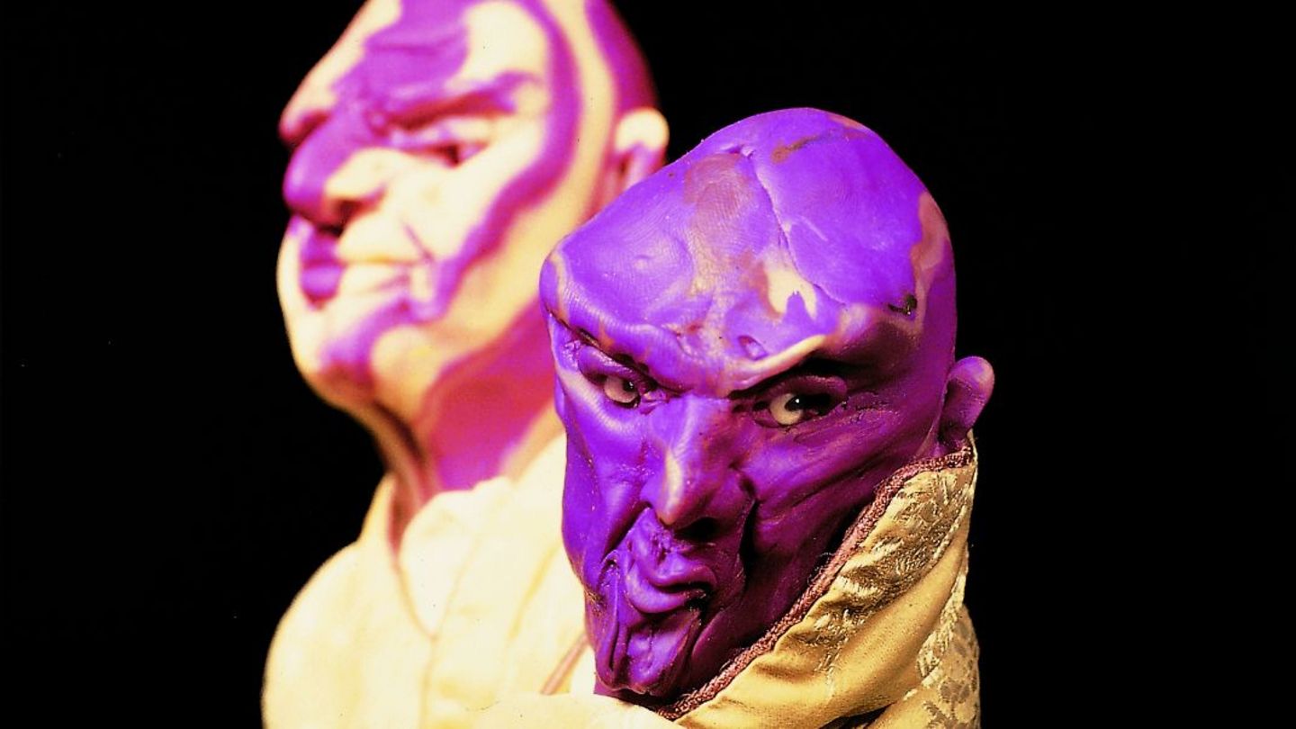 This photograph consists of a close-up of two male head sculptures. They have no hair, but an expressive facial expression. They are also dressed with high-quality fabrics. 