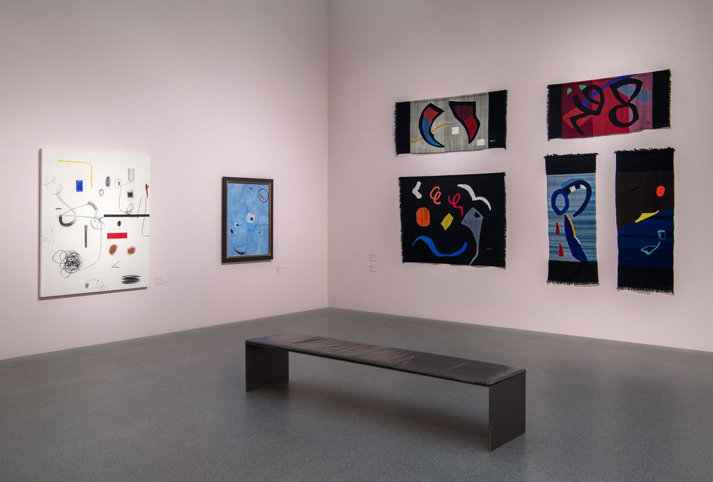 Ausstellungsraum der Pinakothek der Moderne mit abstrakten Gemälden von Christian Rosa und Joan Miro sowie Wandteppichen von Woty Werner, Sammlung Goetz, München