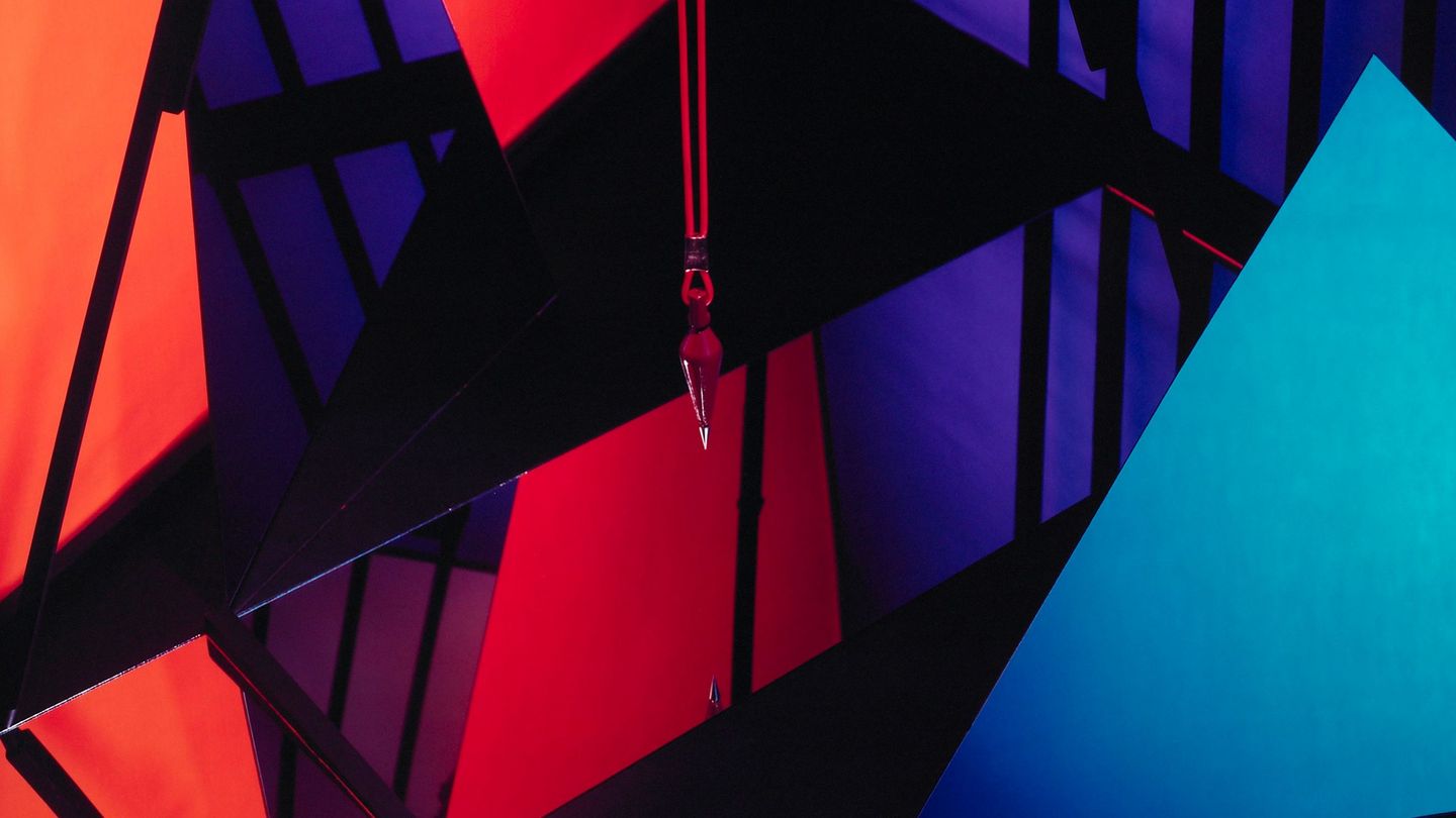 Color photograph of an abstract geometric composition made of mirrors, a pendulum, and other objects that cannot be individually identified, Barbara Kasten, Sammlung Goetz, Munich.