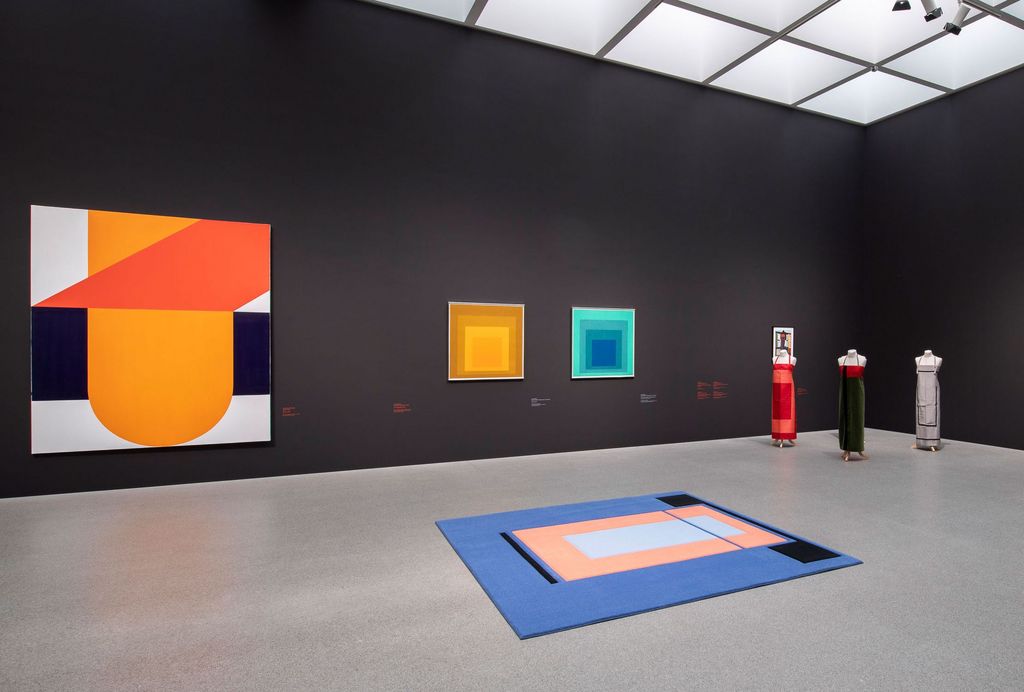 Ausstellungsraum der Pinakothek der Moderne mit geometrisch-abstrakten Gemälden von Takesada Matsutani und Josef Albers, sowie Textile Arbeiten (Teppich, Kleider) von Andrea Zittel, Sammlung Goetz, München 