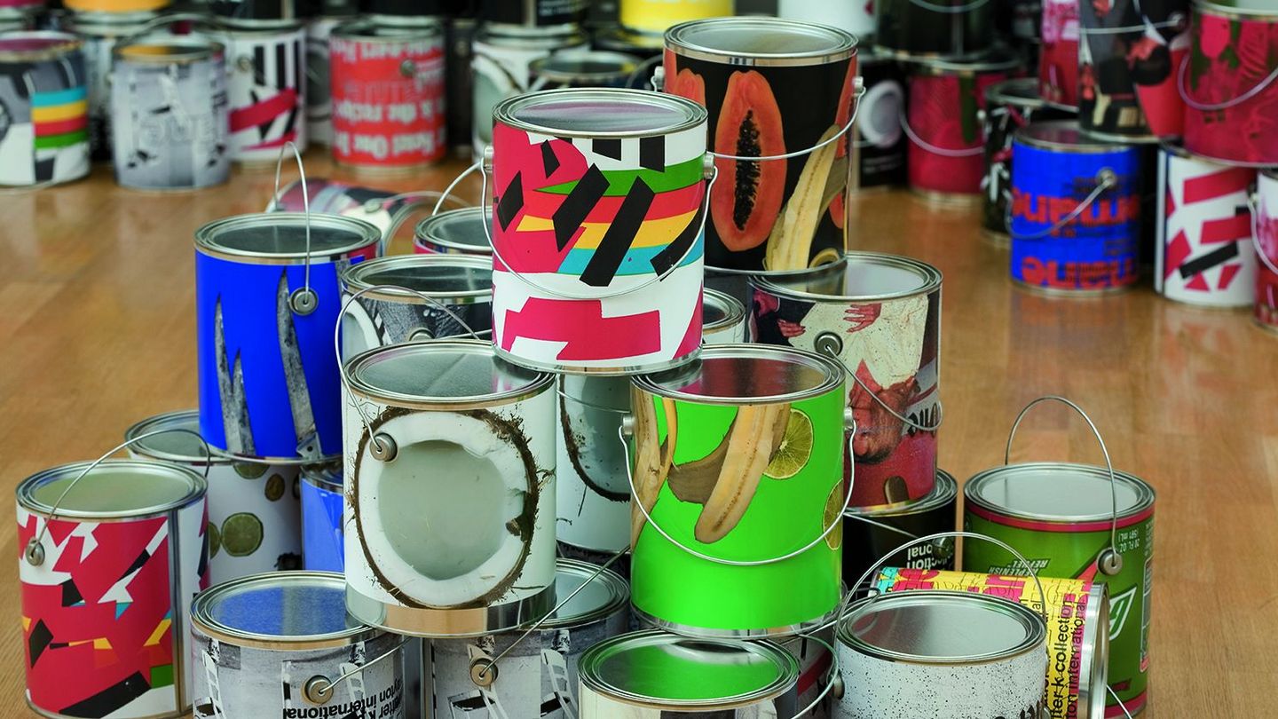 This installation shot features silver paint buckets printed with color copies in the foreground and background. Wade Guyton/Kelley Walker, Sammlung Goetz Munich